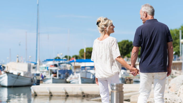 Couple walking along harbour Couple walking along harbour